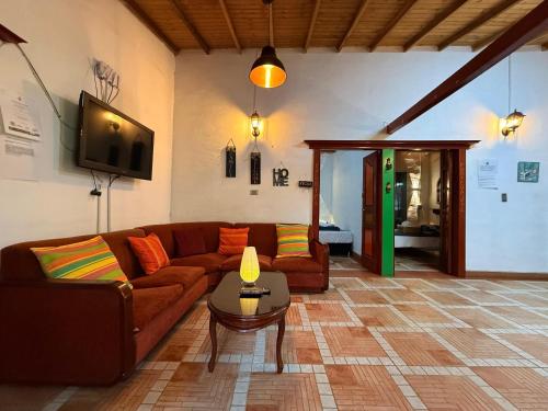 a living room with a couch and a table at Cabaña ideal 5-9 personas cocina, wifi, cerca al parque y campestre in Jardin