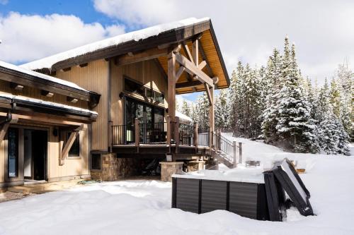 a log cabin in the snow with a balcony at 360 Chalet in Big Sky