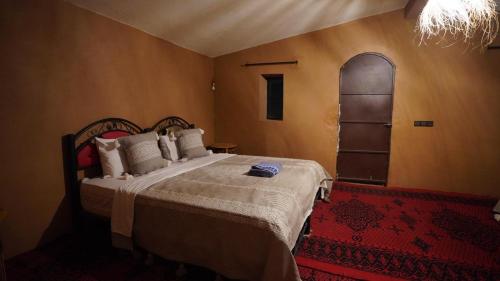 ein Schlafzimmer mit einem Bett und einem Bogenfenster in der Unterkunft Mhamid Nomad Camp in Mhamid