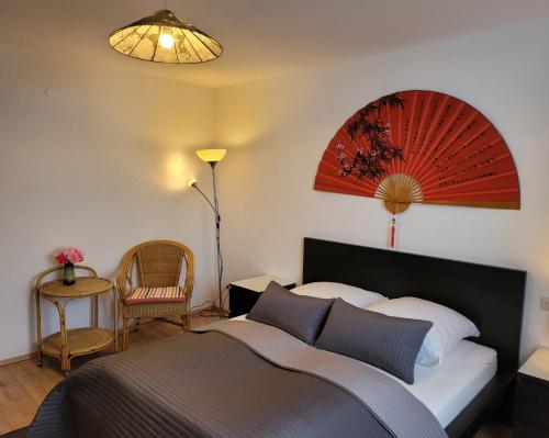 a bedroom with a bed and a lamp and a chair at Mountain-top with balcony in Schonach