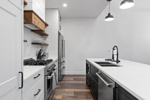 a kitchen with black and white counters and a sink at Alpine Glow Ski Haus in Whitefish