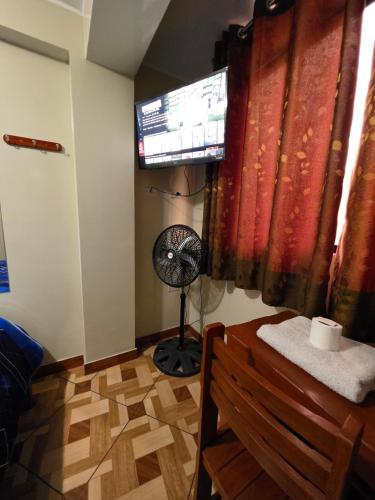 a room with a fan and a window in a room at Hospedaje Escorpio in Lima