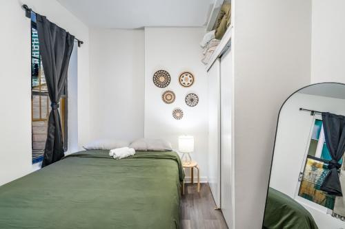 a bedroom with a green bed and a mirror at Oasis Apartment by Columbus Circle & Times Square in Manhattan in New York