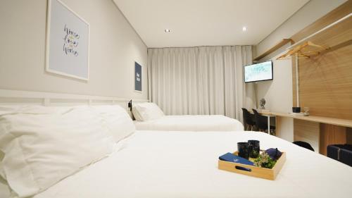 a hotel room with two beds and a tv at Apê Brás - Shopping Plaza Polo in Sao Paulo