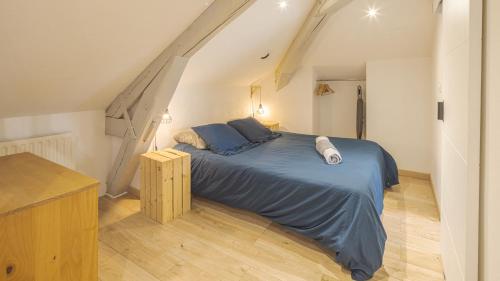 a bedroom with a blue bed in a attic at Le Saint Nicolas in Troyes