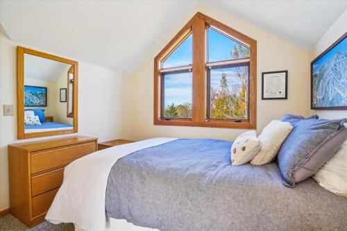 une chambre avec un lit et une grande fenêtre dans l'établissement Cozy 2BR Highridge Condo Unit I3 in Killington, VT with hot tub and scenic woods view., à Killington Village