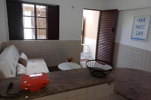 a living room with a couch and a red appliance on a counter at Flat Grand Praia de Iracema in Fortaleza
