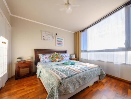 Un dormitorio con una cama y una ventana grande. en Departamento completo con Vista a la Ciudad, a pasos del Metro Santa Isabel, Barrio Italia, providencia, en Santiago