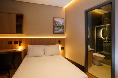a small room with a bed and a bathroom at W Airport Rooms Recife in Recife