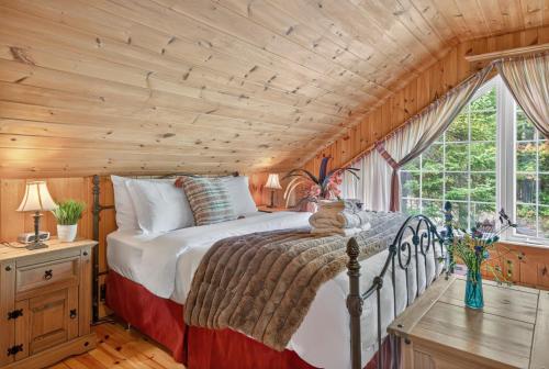 une chambre avec un lit et un plafond en bois dans l'établissement Domaine Rivière Sacacomie - Chalet Le Huard, à Saint-Alexis-des-Monts