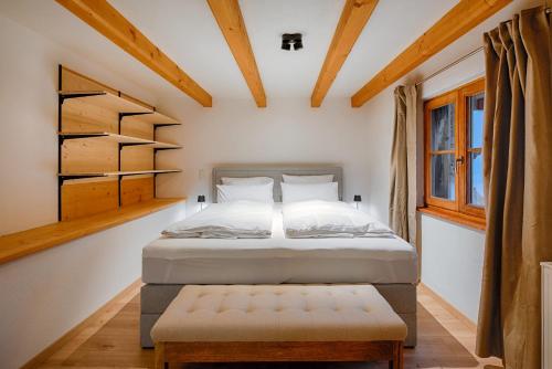 une chambre avec un lit et un banc dans l'établissement Stube & Stories - Heritage Riverside Home, à Garmisch-Partenkirchen