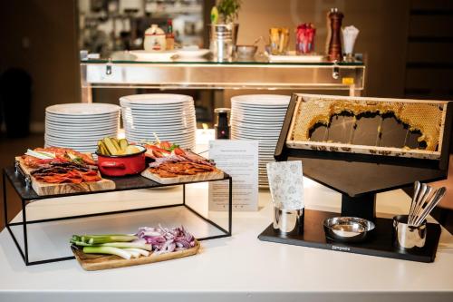 uma mesa com duas bandejas de comida e pratos em Corso Hotel Pécs em Pécs