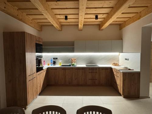 una cocina con armarios de madera y techos de madera. en Chata pod Jabloňou, en Banská Štiavnica