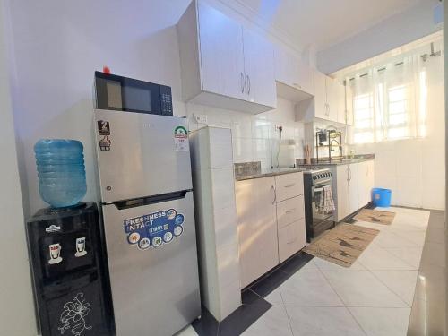 a kitchen with a refrigerator and a stove at Del's Homes -Ruiru in Ruiru
