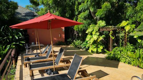 サン・アンドレスにあるHotel Acantilado de La Tierra by On vacationのパティオ(椅子、赤い傘付)