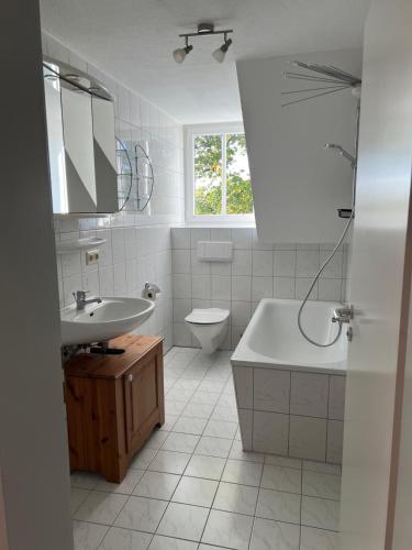 ヴァインガルテンにあるApartment im Welfenpalaisの洗面台、浴槽、トイレを備えたバスルーム