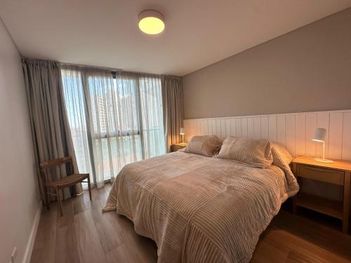 a bedroom with a bed and a large window at Clara Suite in Mar del Plata