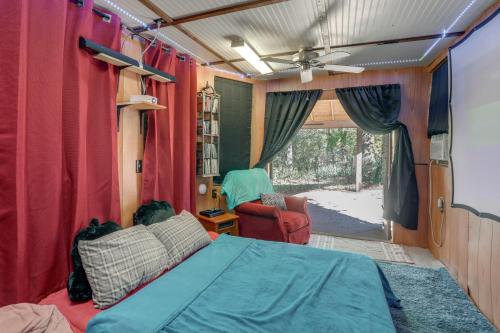 a bedroom with a bed and red curtains and a window at The Treehouse in Cherokee Village Deck and Views in Hardy
