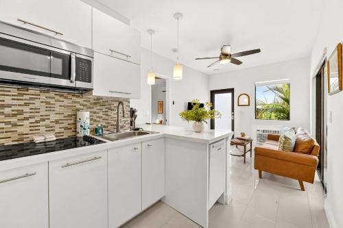 een keuken met witte kasten en een plafondventilator bij Chic Modern Studio with Queen Bed in Fort Lauderdale
