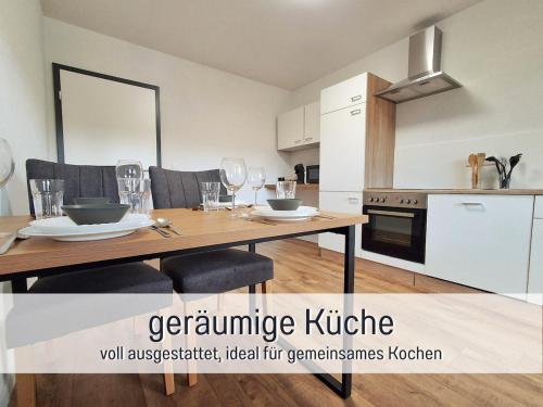 a kitchen with a wooden table with wine glasses at Germersheimer Rhein-Quartier in Germersheim