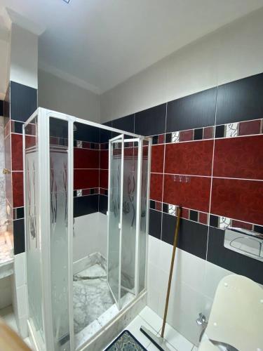 une salle de bain avec douche aux carreaux rouges et noirs dans l'établissement Spacious apartment inside a resort, à Charm el-Cheikh