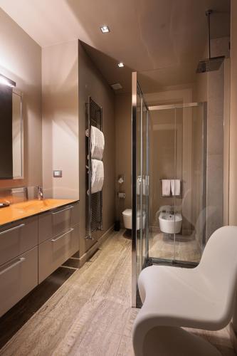 a bathroom with a shower and a sink and a toilet at Escalus Luxury Suites Verona in Verona