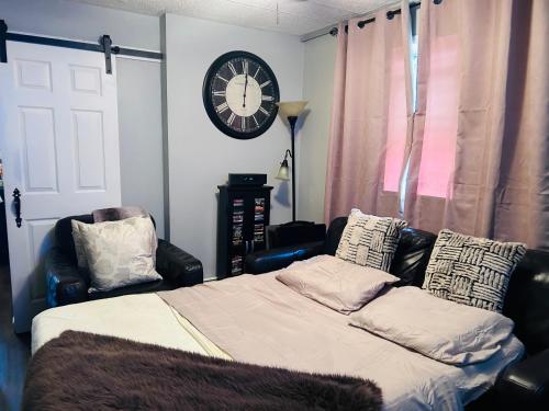a bedroom with a bed and a clock on the wall at The Layover Lounge in Elizabeth