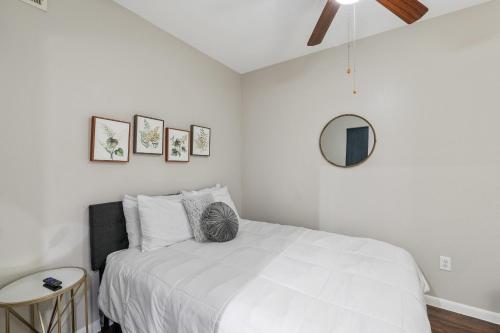 ヒューストンにあるTrendy, upscale apartment!の白いベッドと鏡のある寝室