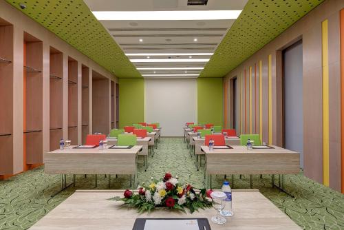a row of tables in a room with green walls at Al Khoory Atrium in Dubai