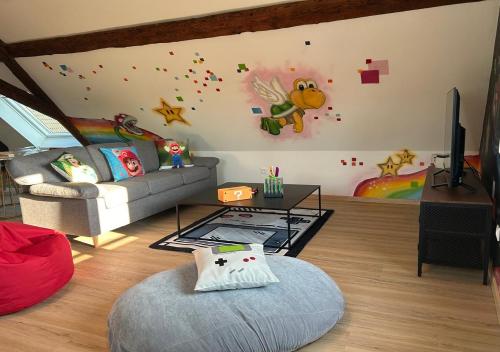 a living room with a couch and a wall at Sur la Route Arc-en-Ciel - Expérience Unique proche Europa-park in Muttersholtz