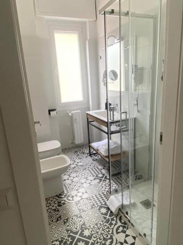 a bathroom with a glass shower and a toilet at Pitia House in Rozzano