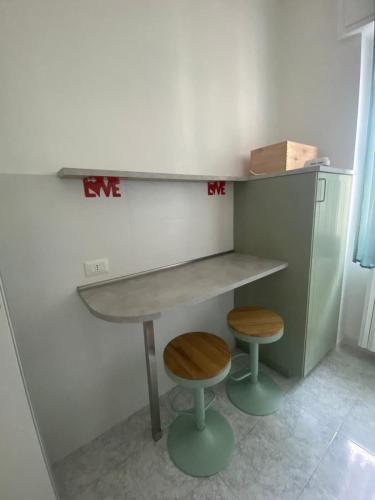 a kitchen with a counter and two stools at Pitia House in Rozzano