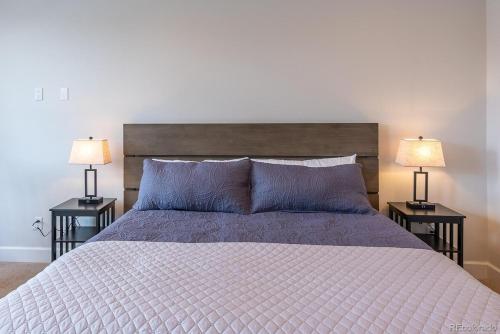 a bedroom with a large bed with two lamps on tables at Stylish Grand Lake Retreat - King Bed - Walk to Lake in Grand Lake