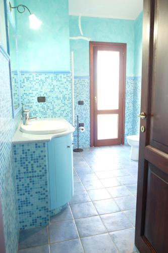 a blue bathroom with a sink and a toilet at B&B Sa Sinniesa in Sìnnai