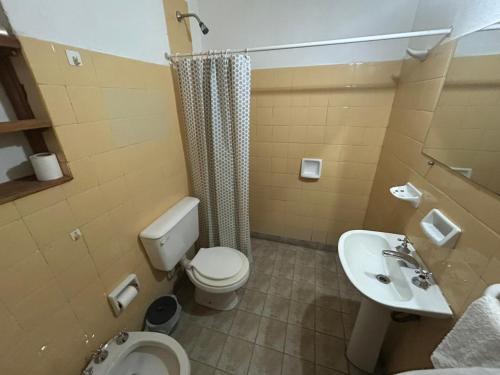 a bathroom with a toilet and a sink at depto de montaña con pileta in La Cumbre