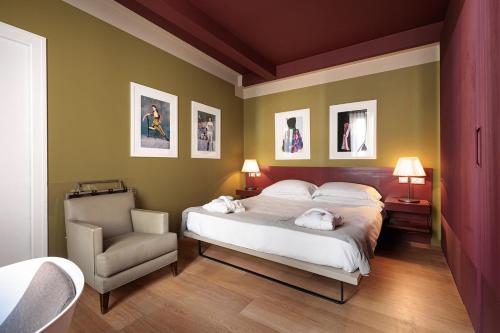 a bedroom with a bed and a chair at Escalus Luxury Suites Verona in Verona