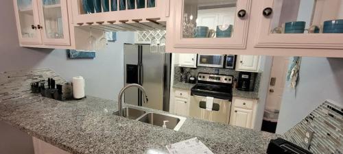 a kitchen with a sink and a refrigerator at EZ Walk to Beach Modern 2 bedroom Sleeps Many in South Padre Island