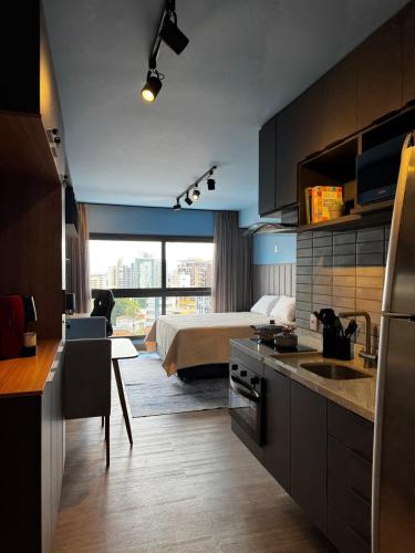 a kitchen and living room with a bed in a room at LIV apto 1211 - Loft novo com vista in Porto Alegre