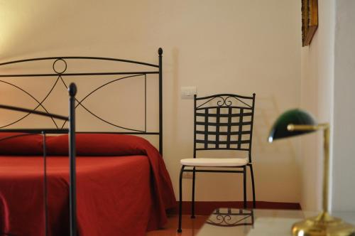 a bedroom with a bed and a chair and a lamp at Suite Carducci B&B - Residence in Rutigliano
