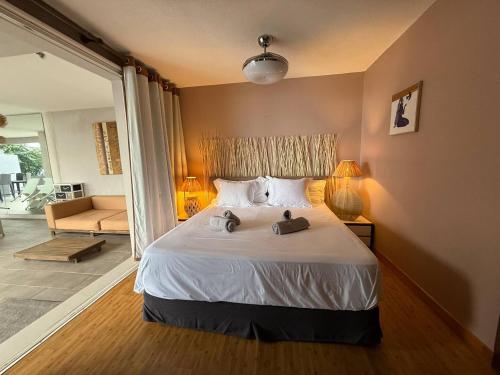 een slaapkamer met een bed met twee handdoeken erop bij Villa ATA ITI in Punaauia