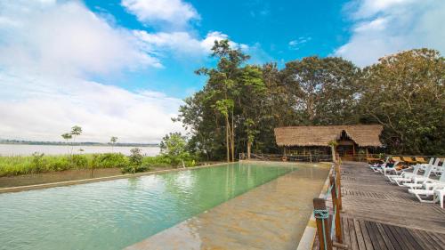 a swimming pool at a resort with chairs and water at Hotel Amazon by On Vacation in Leticia
