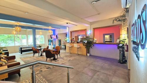 a lobby with a restaurant with a bar and chairs at Somos Hotel San Juan in San Juan