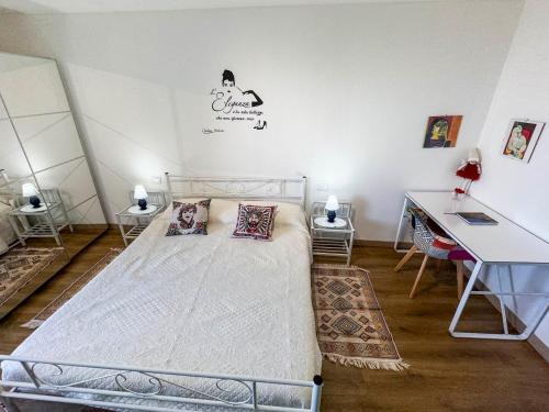 a bedroom with a bed and a desk and a table at Ca' Sole in Butera