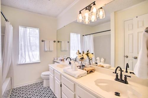 a white bathroom with a sink and a mirror at Pet-Friendly Houston Rental with Private Patio! in Houston