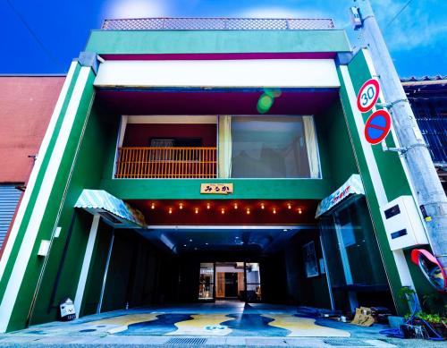 een gebouw met een uithangbord aan de zijkant bij ゲストハウス みるか in Kurayoshi