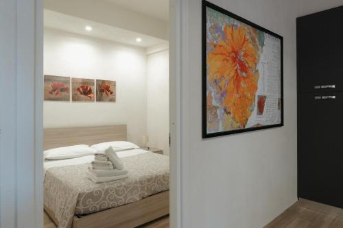 Un dormitorio con una cama y un cuadro en la pared. en Aetna apartment, en Nicolosi