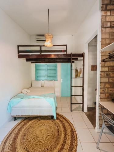 a bedroom with a bed and a rug at Amaly Pousada in Japaratinga