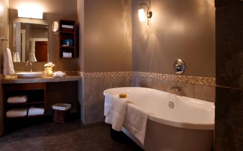 une salle de bain avec une baignoire et un lavabo dans l'établissement Bellstar Suites at Solara Resort, à Canmore