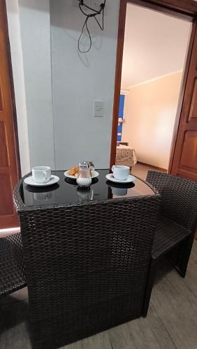 a table with two cups and plates of food on it at Guavirá cabañas and rooms in Puerto Iguazú