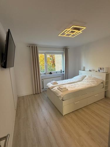 a white bedroom with a bed and a window at 3-room apartment - near airport & Hamburg in Norderstedt